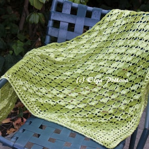 May include: A triangular crochet shawl featuring a variegated yarn pattern in shades of lime green, olive, and dark forest green. The textile displays an openwork diamond stitch pattern with a solid border. The text (c) Olga Poltava is visible.