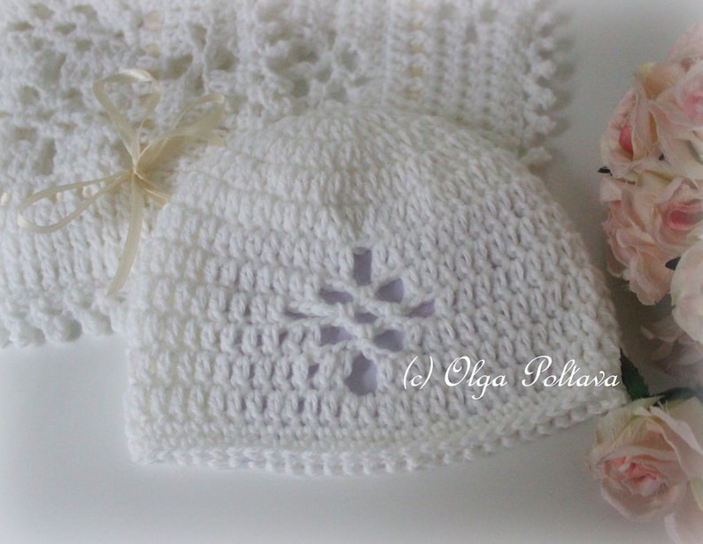 May include: White crocheted baby hat with a flower design. The hat has a hole in the center of the flower. (c) Olga Poltava