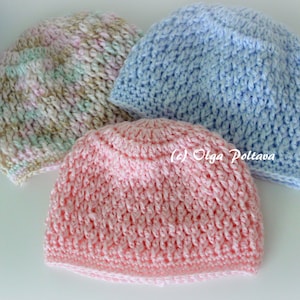 May include: Three crocheted hats in pink, blue, and a multi-colored pattern. The hats are made with a textured stitch.