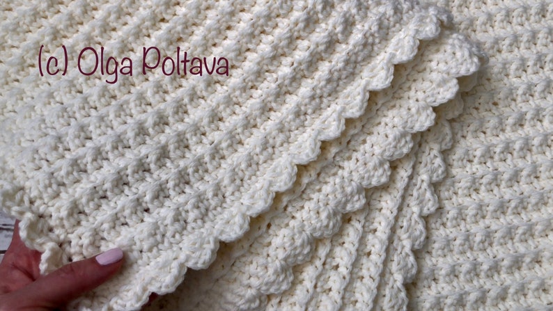 Puede incluir: Una manta blanca de ganchillo con un borde festoneado. La manta est&aacute; doblada en capas, mostrando el intrincado patr&oacute;n de puntadas. El texto (c) Olga Poltava es visible en la esquina superior izquierda.