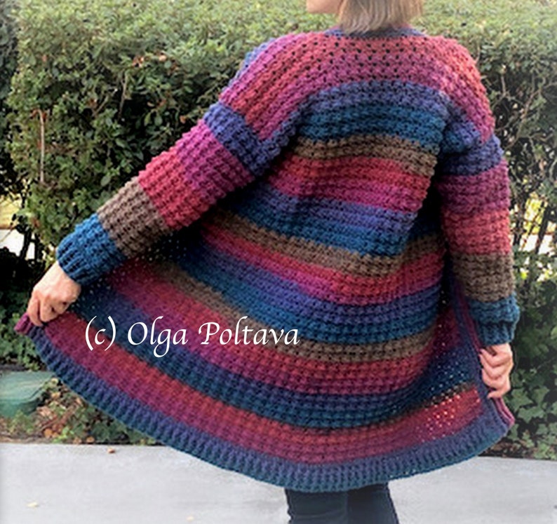 May include: A handmade, open-front cardigan in a textured stitch, featuring horizontal stripes of various colors including burgundy, blue, brown, and purple. The sleeves are long, and the cardigan falls to mid-thigh length. The text "(c) Olga Poltava" is visible.