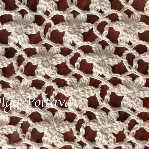 May include: A close-up of a crocheted doily with a delicate floral pattern in a cream color. The doily is laid out on a wooden surface.