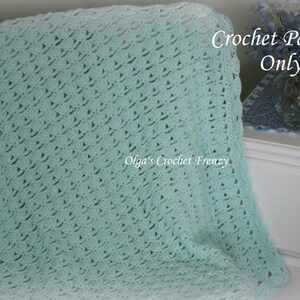 May include: A light blue crochet blanket with a delicate stitch pattern. The blanket is folded and draped over a chair. The text "Crochet Pattern Only" is visible in the upper right corner of the image.