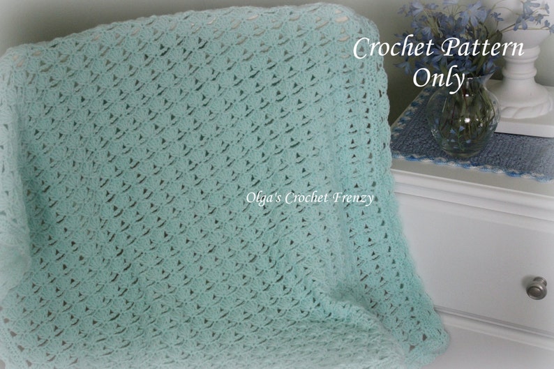 May include: A light blue crochet blanket with a delicate stitch pattern. The blanket is folded and draped over a chair. The text "Crochet Pattern Only" is visible in the upper right corner of the image.