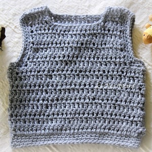 May include: A gray crocheted sleeveless vest with a round neckline.