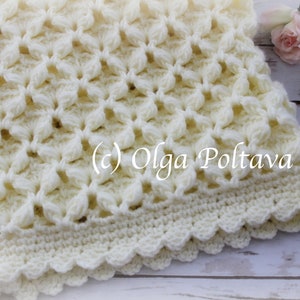 May include: A white crocheted baby blanket with a scalloped edge. The blanket is made with a delicate stitch pattern and has a soft, fluffy texture. (c) Olga Poltava