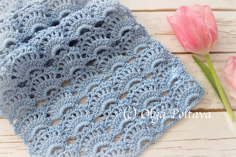 May include: A light blue crocheted scarf with a delicate, lacy pattern. The scarf is made with a fine yarn and has a soft, airy feel.