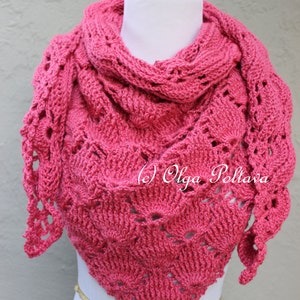 May include: A pink crocheted shawl with a lacy design. The shawl is draped over a white mannequin.
