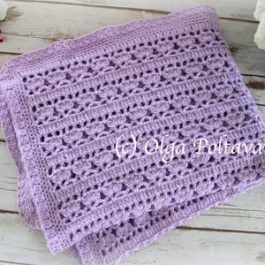 May include: A lavender crochet baby blanket with a delicate stitch pattern. The blanket is folded in half and has a scalloped edge.