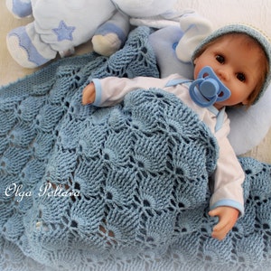 May include: A blue crocheted baby blanket with a white and blue stuffed animal and a baby doll wearing a blue hat and a dummy.