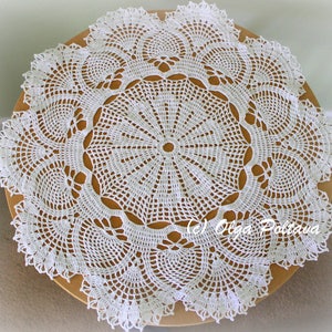 May include: White crocheted doily with a delicate floral pattern. The doily is circular and has a diameter of approximately 18 inches.