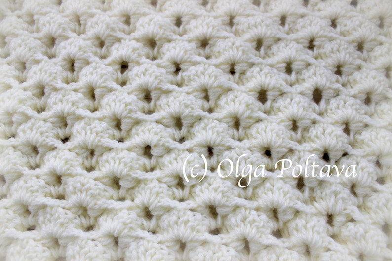 Puede incluir: Primer plano de una tela de crochet blanca con un patr&oacute;n repetitivo de peque&ntilde;os c&iacute;rculos. La tela es suave y texturizada.