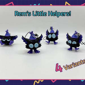 May include: Four black and purple creature figurines with light blue eyes and purple pointed hats, each attached to a black cord keychain. The text Rem's Little Helpers! and 4 Variants! is displayed in the image with these small character charms.