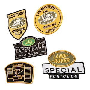 Op de afbeelding: Vijf geborduurde patches met Land Rover-branding. Eén schildvormige patch leest Scottish Land Rover Owners Club. Een ronde patch leest Authorized 4x4 Land Rover Series One Owner. Een zwarte rechthoekige patch leest Land Rover Experience 4x4 Driving. Een zwarte patch leest Series III Owners Club. Een laatste patch toont het Land Rover-logo boven de tekst Special Vehicles.