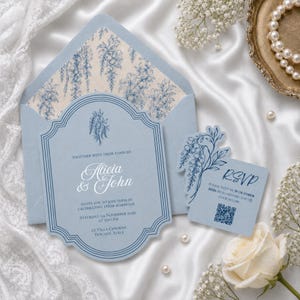 May include: A light blue wedding invitation suite featuring a scalloped card with dark blue floral line art, the names Alicia & John, and event details. Includes a matching RSVP card with a QR code and a blue envelope with a floral liner.