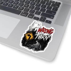 May include: A die-cut sticker featuring a dark forest road scene with a yellow road sign showing a left turn arrow. Above the road, a white ghost floats near the red and white text that reads WRONG TURN. The sticker has a white border.