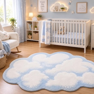 May include: A cloud-shaped area rug featuring a soft, textured pattern of white clouds against a light blue background. The rug has a rounded, irregular perimeter that mimics the organic, fluffy appearance of a cumulus cloud formation.