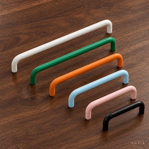 May include: A set of six U-shaped cabinet pulls in varying lengths and colors, including white, green, orange, light blue, pink, and black. Each handle features a smooth, rounded design with two mounting points. The brand name XUTIA is visible.