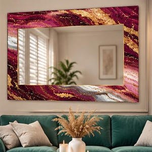 May include: A rectangular wall mirror featuring a wide frame with a vibrant abstract pattern in shades of deep magenta, burgundy, and white, accented with shimmering gold veins that create a marbled effect across the entire border surface.