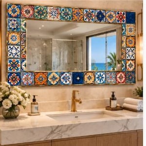May include: A rectangular wall mirror featuring a decorative frame composed of colorful square tiles in shades of blue, orange, yellow, and white with intricate geometric and floral patterns surrounding a clear reflective glass surface.