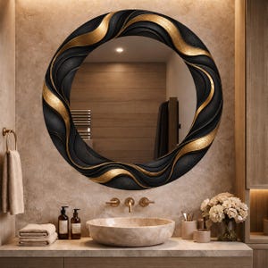 May include: A circular wall mirror featuring a decorative frame with a textured black finish and flowing, wave-like gold accents. The mirror reflects a bathroom interior, showing a beige stone vessel sink and a neutral-toned vanity countertop.