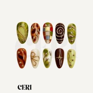 Op de afbeelding: Tien amandelvormige press-on nagels met diverse ontwerpen, waaronder groene en bruine marmerpatronen, een veelkleurig raster, gouden draadspiralen, metalen studs en heldere strass-steentjes. De tekst CERI is onderaan zichtbaar.