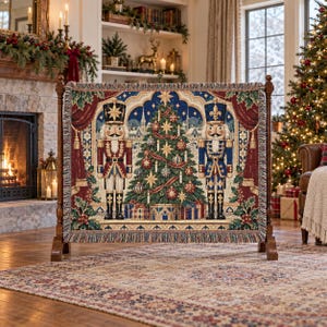 May include: A woven tapestry throw blanket featuring a central Christmas tree decorated with ornaments and stars, flanked by two nutcracker figures in red and blue uniforms, framed by red curtains and holly leaves with a fringed edge finish.
