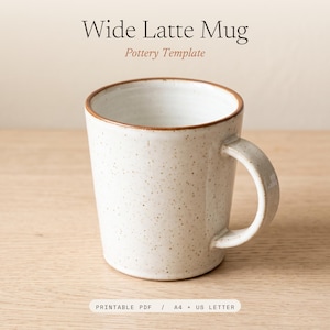 May include: A wide latte mug with a speckled off-white glaze and a brown rim. The text above reads Wide Latte Mug Pottery Template, and the text below reads PRINTABLE PDF / A4 + US LETTER. The mug has a sturdy handle and a cylindrical shape.
