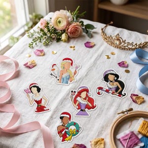 May include: Five die-cut stickers featuring stylized female figures dressed in festive holiday attire. The characters include a blonde with a snowman, a dark-haired figure with a candy cane, a red-haired figure, a dark-haired figure in red, and a figure holding a wreath.