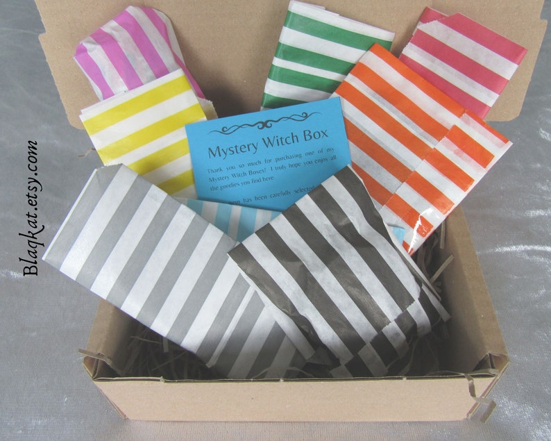 Treat yourself or a loved one to a Witchy Mystery Box. Photo of a Medium Box with 8 items all individually wrapped in stripey paper bags