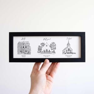 May include: A black rectangular frame containing a white print with three black ink architectural illustrations. The text reads Hello, Will you?, and I Do!, with locations Boston, Napa Valley, and Charleston and dates below each.