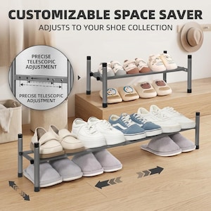 May include: A grey, two-tier adjustable shoe rack with telescopic bars for width customization. The text reads CUSTOMIZABLE SPACE SAVER, ADJUSTS TO YOUR SHOE COLLECTION, and PRECISE TELESCOPIC ADJUSTMENT. It holds various shoes and slippers.