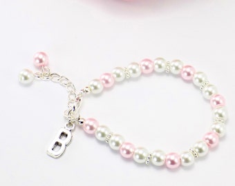 Könnte beinhalten: Ein rosa-weißes Perlenarmband mit einem silbernen Anhänger, auf dem "B" steht.