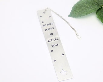 May include: Silver bookmark with a chain. The bookmark has a star cut out and the text "So many books, so little time".