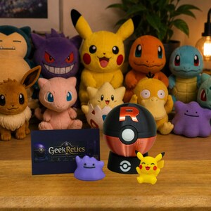 Könnte beinhalten: Eine Sammlung von Plüschtieren, darunter Snorlax, Gengar, Pikachu, Charmander, Squirtle, Eevee, Mew, Togepi, Psyduck, Ditto und Bulbasaur, sowie ein Team Rocket Ball, eine kleine Pikachu-Figur, eine lila Ditto-Figur und eine GeekRelics-Karte.