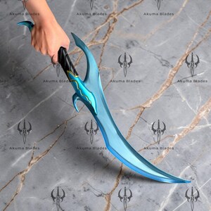 May include: A curved fantasy blade featuring a metallic light blue finish with a sharp, pointed tip. The handle is black with gold accents and a distinct guard design. The blade displays a wavy, decorative line along the center of the ricasso.