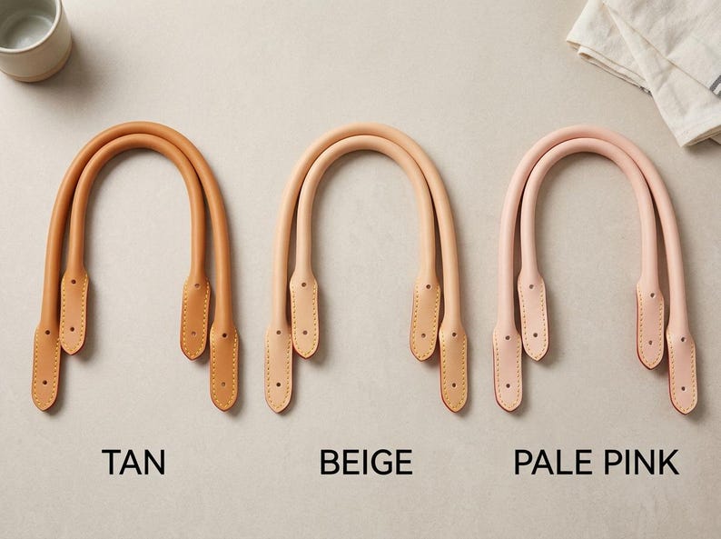 Puede incluir: Tres pares de asas de cuero redondeadas para bolsos en color tostado, beige y rosa p&aacute;lido. Cada asa presenta extremos cosidos con dos orificios preperforados para su fijaci&oacute;n. El texto TAN, BEIGE y PALE PINK aparece bajo cada juego.