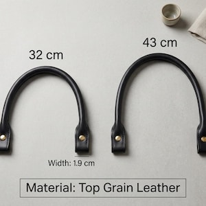 Puede incluir: Dos asas de bolso de cuero de grano superior en color negro con remaches met&aacute;licos dorados. Un asa mide 32 cm y la otra 43 cm de largo. Ambas asas tienen un ancho de 1,9 cm. El texto en la imagen indica que el material es cuero de grano superior.
