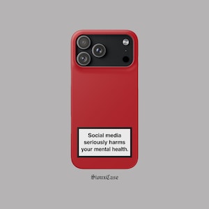 Peut inclure: Une coque de smartphone rouge uni avec une étiquette rectangulaire blanche à bordure noire. L'étiquette porte le texte noir : Social media seriously harms your mental health. La coque présente un module photo noir en haut.
