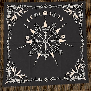 Peut inclure: Un tissu carré noir présentant un motif imprimé blanc d'un symbole de boussole Vegvisir au centre, entouré de divers caractères runiques, de phases lunaires et de fioritures florales décoratives dans les coins, disposés symétriquement.