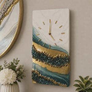 May include: A rectangular wall clock featuring a white marble-effect background with gold and teal fluid accents. The clock face has gold-colored hands and markers, with textured, crystalline dark teal and gold embellishments across the lower half.