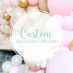 May include: A custom balloon garland featuring pink, white and gold balloons. The garland is decorated with small white flowers. The text "Custom Balloon Garland" is written in a circle in the centre of the image.