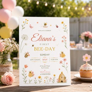 May include: A white rectangular party invitation sign featuring watercolour illustrations of bees, flowers, and a beehive. The text reads: JOIN US TO CELEBRATE Eliana's FIRST BEE-DAY SUNDAY 30TH AUGUST 202X 5:00 PM 43 Howard Street, San Francisco RSVP to Emma at 09863251286.