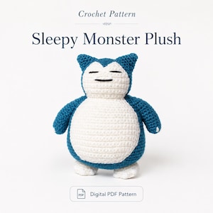 May include: A crochet pattern titled Sleepy Monster Plush featuring a blue and white stuffed creature with closed eyes and a round belly. The text Crochet Pattern and Digital PDF Pattern are visible on the white background above and below the plush.