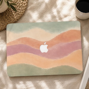 May include: A laptop cover featuring a horizontal wavy pattern in muted shades of sage green, soft peach, and dusty rose. The design has a textured, watercolour-like appearance with soft edges between the colours and a central cutout for the Apple logo.