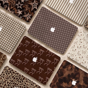 Peut inclure: Une collection de skins pour ordinateur portable présentant divers motifs marron et beige, notamment des étoiles, des rayures, des pois, des imprimés léopard, du vichy, des nœuds, des papillons et des motifs floraux avec le logo Apple.