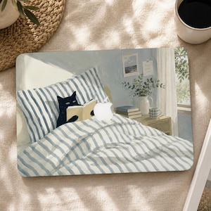 May include: A rectangular laptop skin featuring an illustration of a black cat reading a book while lying in a bed with blue and white striped bedding. The design includes a white Apple logo cutout, a bedside table with books, a plant, and a mug.