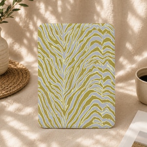 May include: A rectangular tablet case featuring a repeating zebra stripe pattern in shades of mustard yellow and light gray. The case has rounded corners and a smooth, flat surface, displaying a consistent animal-inspired print across the front.
