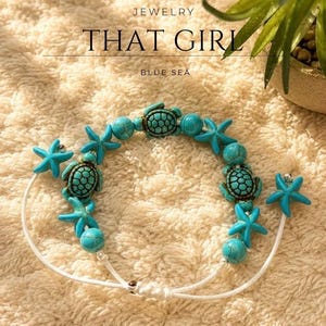 Könnte beinhalten: Ein Armband mit türkisfarbenen Perlen, Meeresschildkröten-Anhängern und Seestern-Anhängern an einer weißen Schnur. Der Text "JEWELRY THAT GIRL BLUE SEA" ist über dem Armband zu sehen. Die Perlen haben eine marmorierte Textur und Details.