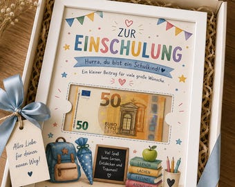 May include: A white gift box containing a framed print with the text Zur Einschulung, featuring a 50 Euro banknote, a blue backpack, a chalkboard, a stack of books, and an apple. A light blue ribbon and a tag with the text Alles Liebe für deinen Weg are attached.